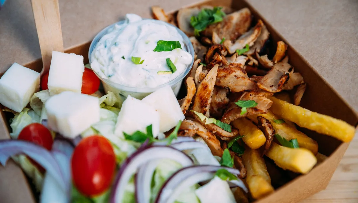 Kyckling gyro-box med tzatziki, pommes och grekisk sallad i en kartongbox