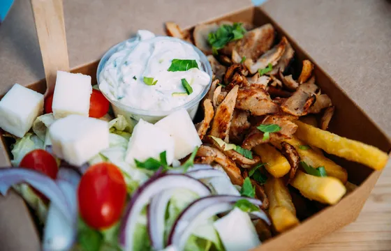Kyckling gyro-box med tzatziki, pommes och grekisk sallad i en kartongbox