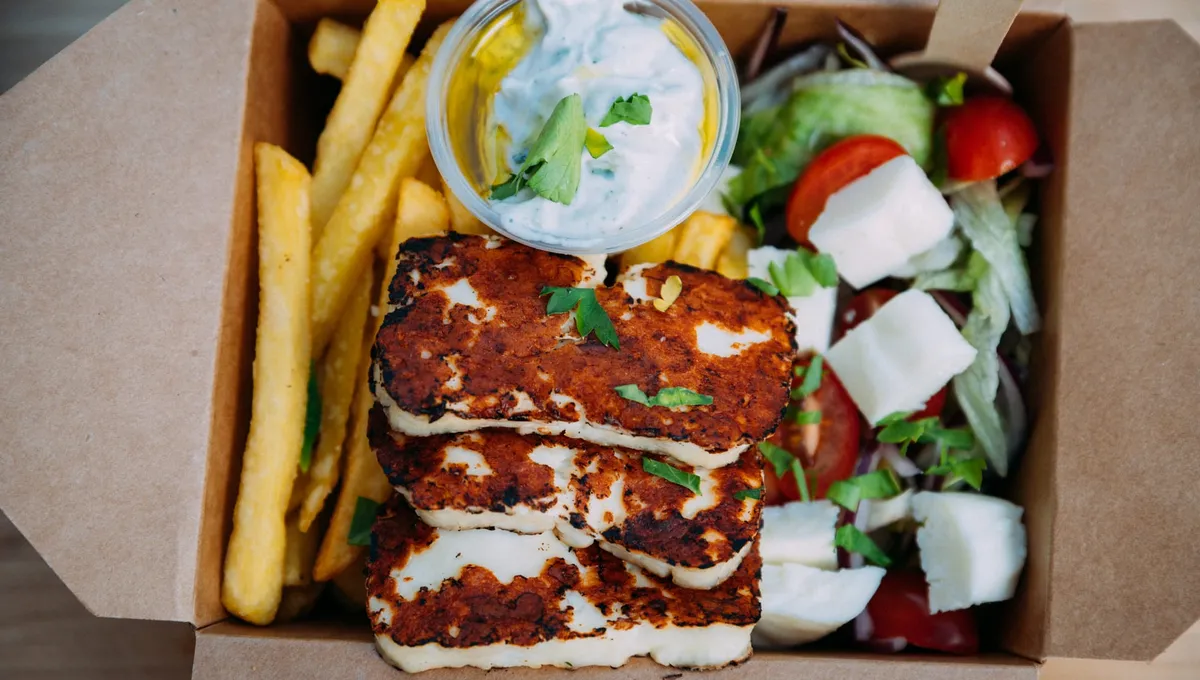 Kartongbox med grillad halloumi, pommes, grekisk sallad och tzatziki
